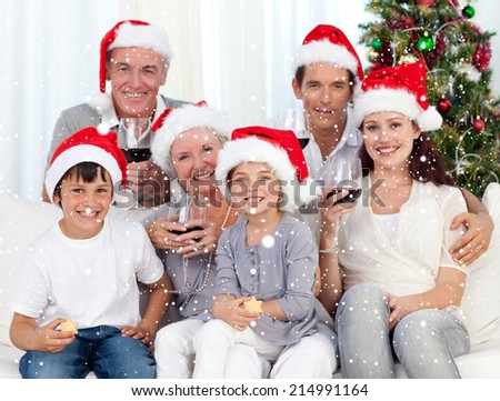 Family celebrating Christmas with wine and sweets against snow falling