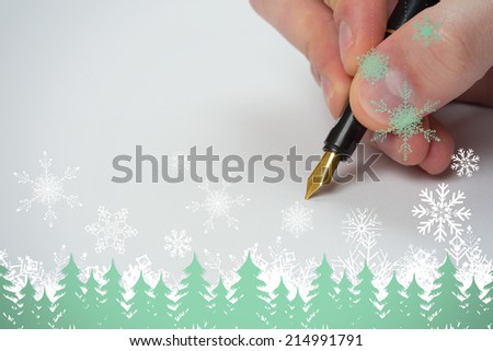 Hand writing with fountain pen against snowflakes and fir trees in green