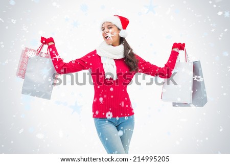 Beautiful festive woman holding shopping bags against snow falling