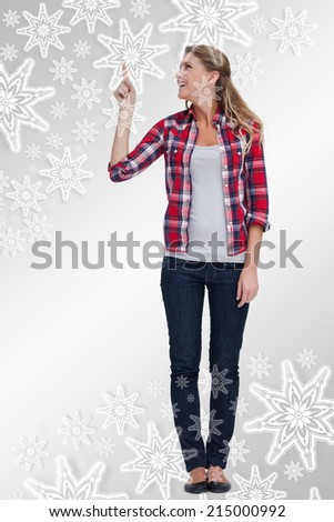 Portrait of a smiling woman pointing at a copy space against snowflakes on silver