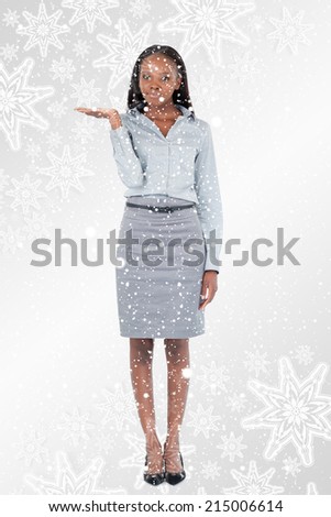 Portrait of a businesswoman presenting something against snowflakes on silver