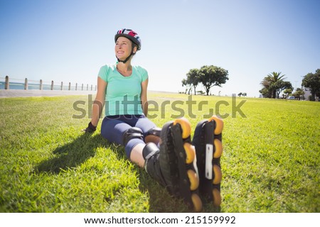 Fit mature woman in roller blades on the grass on a sunny day