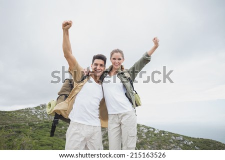 Low angle view of hiking young couple stretching hands on mountain terrain