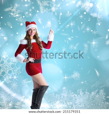 Sexy santa girl pointing against blue snow flake pattern design