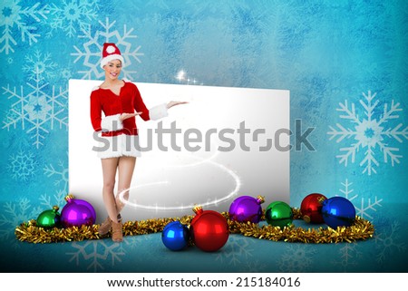 Pretty santa girl presenting with hands against blue snow flake pattern design