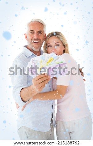 Happy couple flashing their cash against snow falling