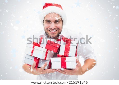 Handsome festive man holding gifts against snow falling
