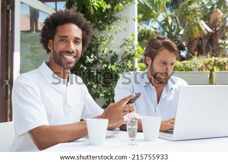 Two busy friends having coffee together outside at the coffee shop