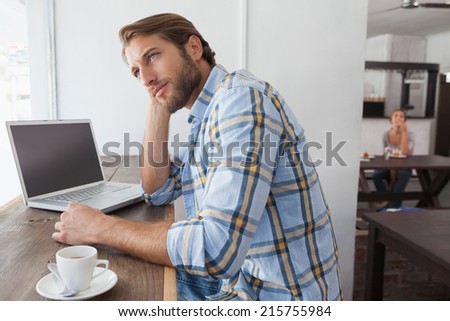 Casual man using laptop having coffee at the coffee shop