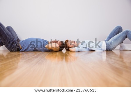 Couple lying on the floor of their new home