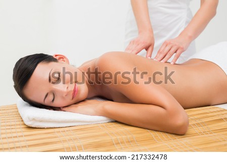 Beautiful brunette enjoying a back massage in the health spa