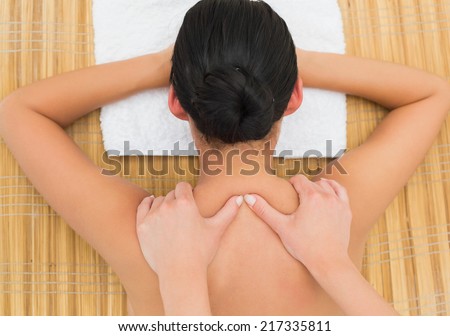 Peaceful brunette enjoying a back massage in the health spa