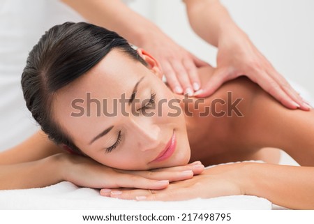 Beautiful brunette enjoying a shoulder massage in the health spa