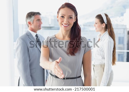 Smiling business woman offering handshake at work