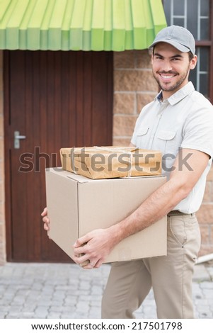 Delivery driver walking with parcels outside the warehouse
