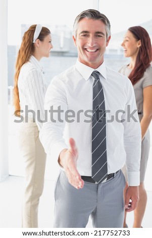 Smiling businessman offering a handshake at work