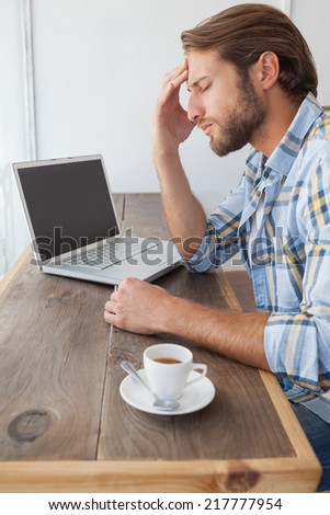 Casual man using laptop having coffee at the coffee shop