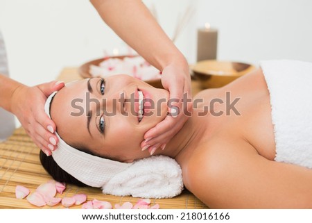 Peaceful brunette enjoying a face massage in the health spa