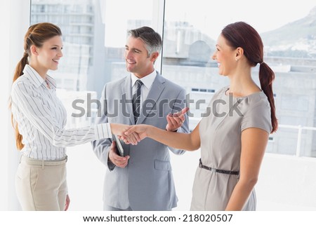 Businesswoman shaking co-workers hand in work