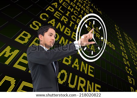 Serious asian businessman pointing to a white clock against black airport departures board for australia