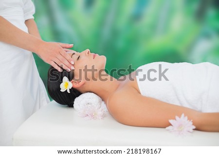 Beautiful brunette enjoying a head massage at a luxury spa