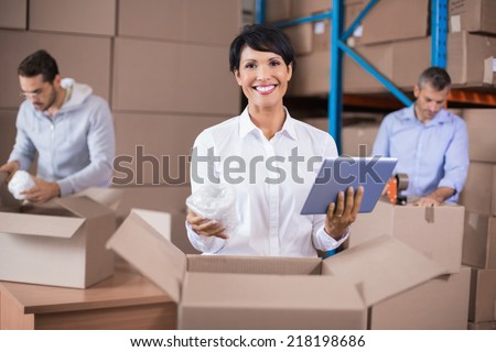 Warehouse workers packing up boxes in a large warehouse