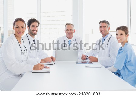 Doctors smiling at the camera as they all sit