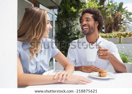 Happy couple having coffee together outside at the coffee shop