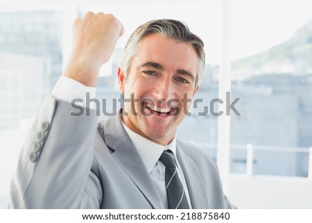 Businessman celebrating a good job in his office