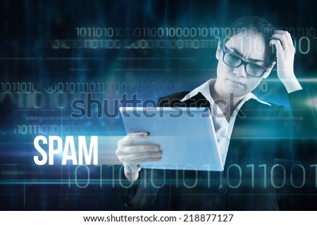 The word spam and thinking businesswoman looking at tablet pc against blue technology design with binary code