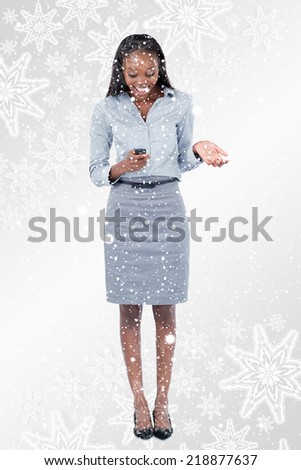 Composite image of Portrait of a surprised businesswoman reading a text message with snowflakes on silver
