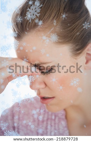 Young woman suffering from headache against snow falling