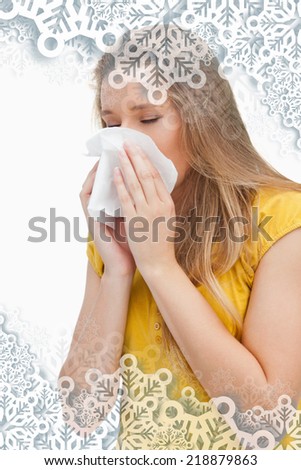 Close up of a blond woman blowing against snowflakes on silver