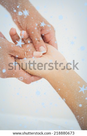 Composite image of Woman receiving a hand massage with snow falling