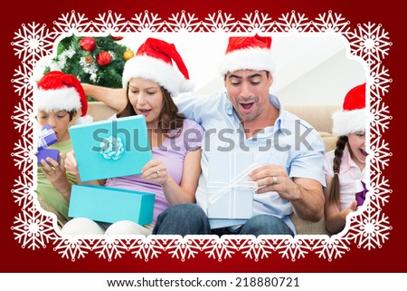 Composite image of family opening Christmas presents against snowflake frame