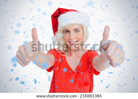 Smiling young woman putting her thumbs up in satisfaction against snow falling