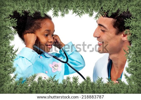 Smiling doctor and his patient playing with a stethoscope against green fir branches