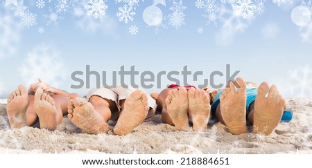 Composite image of a Feet of friends lying together against snowflakes