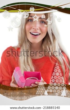 Surprised blonde woman opening gift against christmas frame