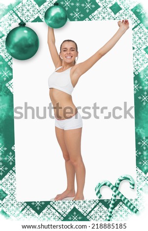 Happy slim woman standing on a scales spreading her arms against christmas frame