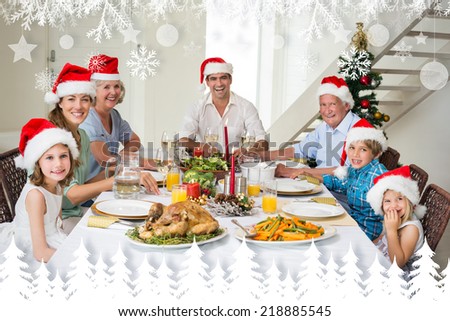 Happy family in Santa hats having Christmas meal against fir tree forest and snowflakes