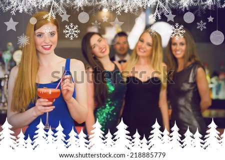 Attractive woman holding cocktail standing in front of her friends against fir tree forest and snowflakes