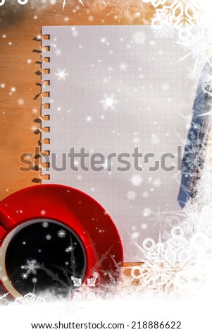 Snow falling on overhead of graph paper coffee and pen