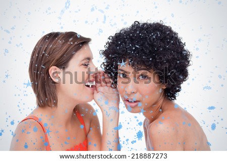 Teenage girl being told a secret by a friend against snow falling