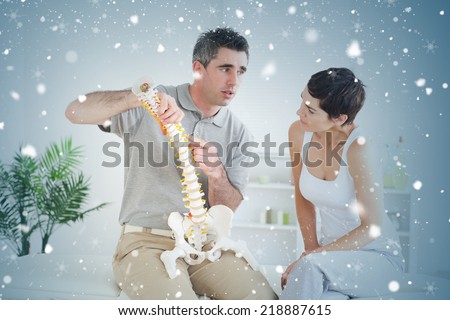 Brunette woman looking at a model spine against snow falling