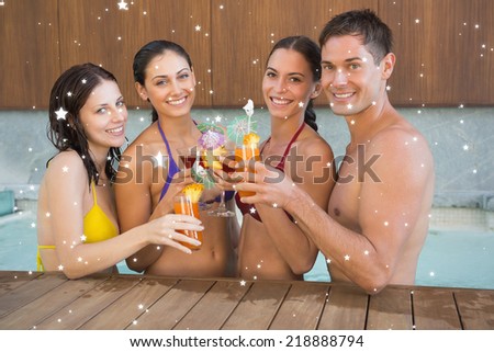 Cheerful people toasting drinks in the swimming pool against snow
