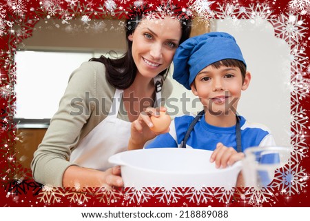 Composite image of mother and son baking cake against snow