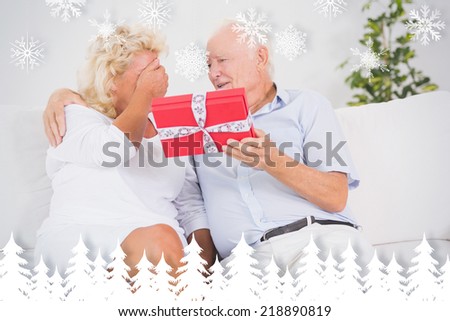 Old man offering a gift to the elderly woman against fir tree forest and snowflakes