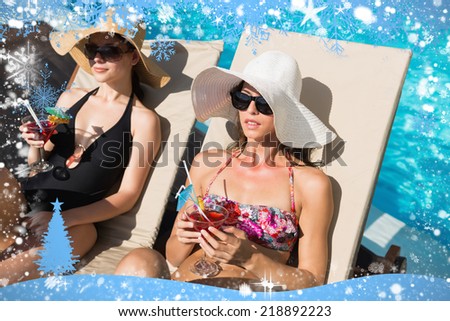 Women holding drinks by swimming pool against snow