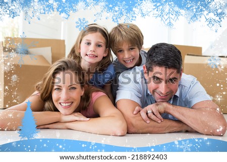 Composite image of snow frame against family lying on floor in new house